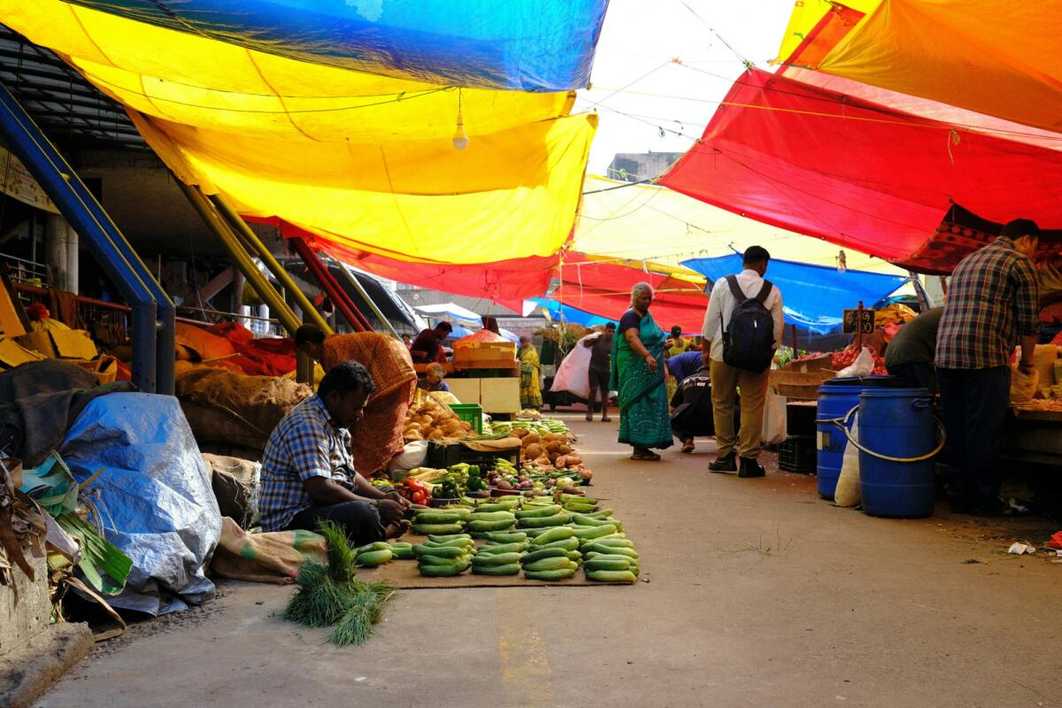 Busy produce market with traders and customers